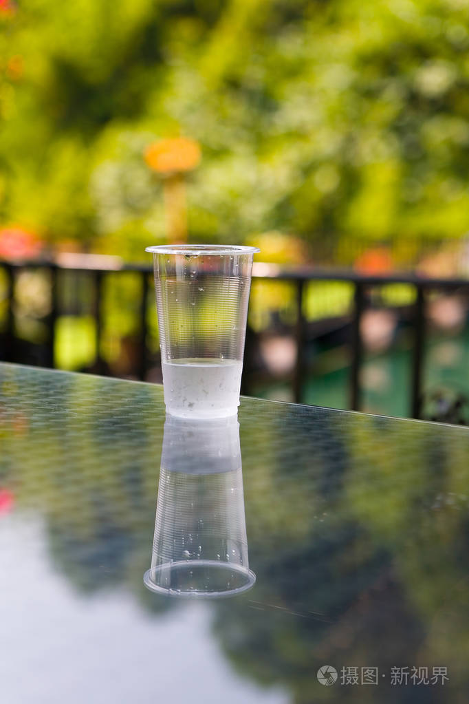 桌上有一个装有水的廉价塑料杯