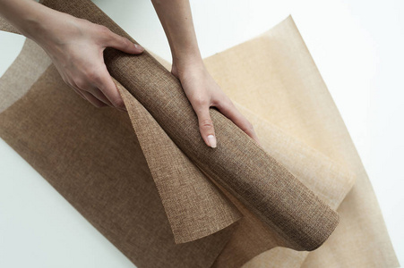 一卷布手里拿着一卷棕色的亚麻照片