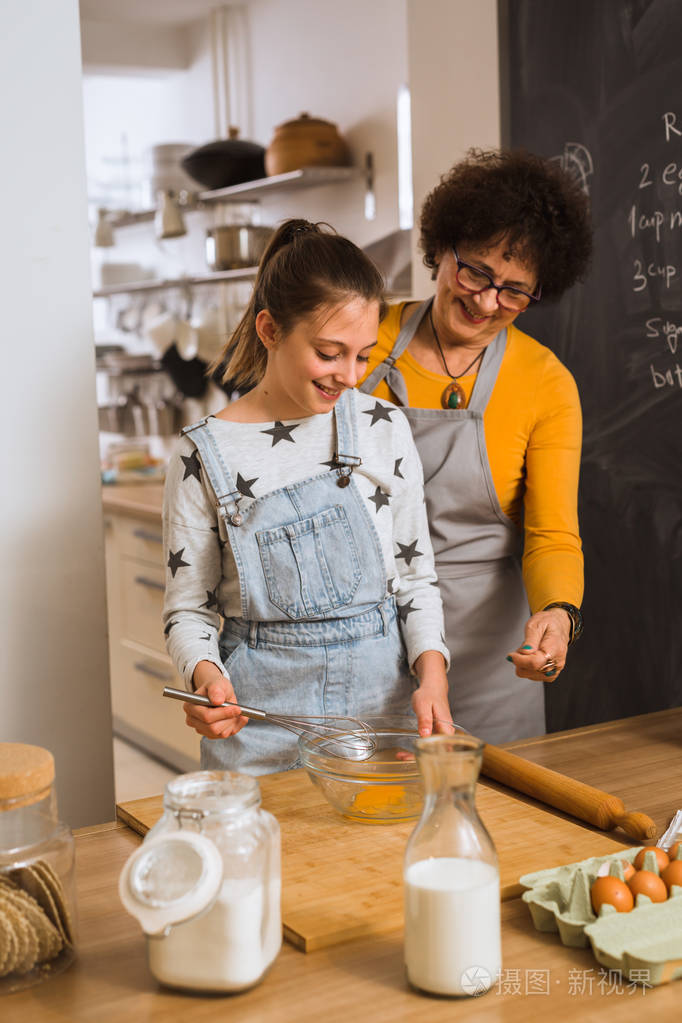 小女孩和奶奶一起在家里的厨房里烤面包