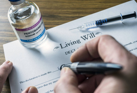 安乐死生前遗嘱申报表旁有一小瓶戊巴比妥钠进行安乐死的概念图照片