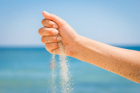 手在海边撒沙子沙子流过女性的手手在海边撒沙子运动