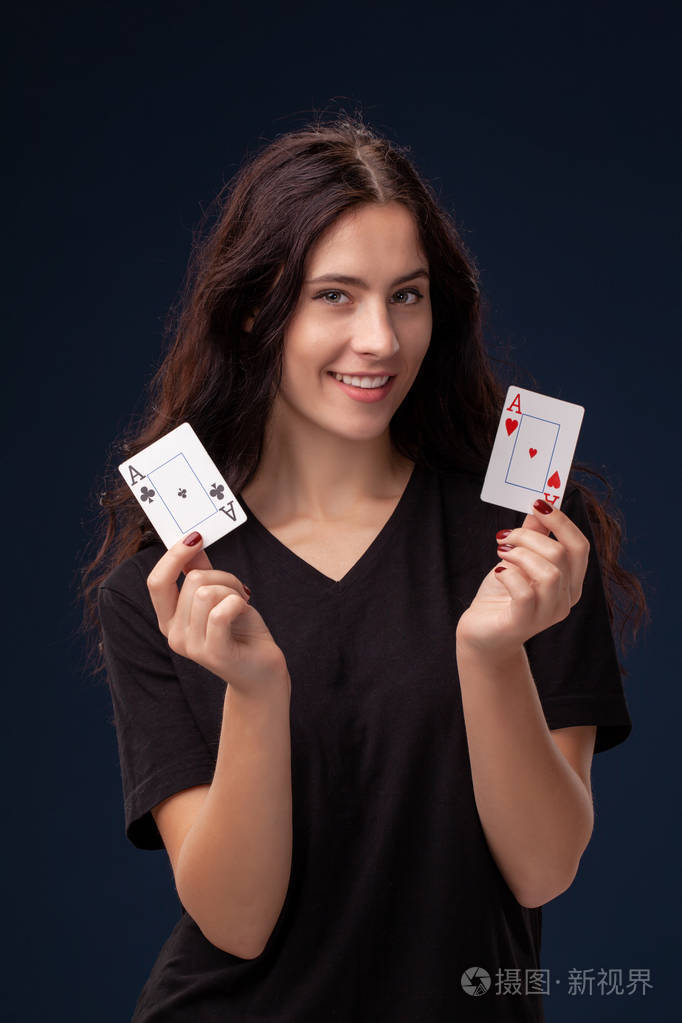 一个卷发的黑发女人手里拿着扑克牌摆姿势的特写镜头.