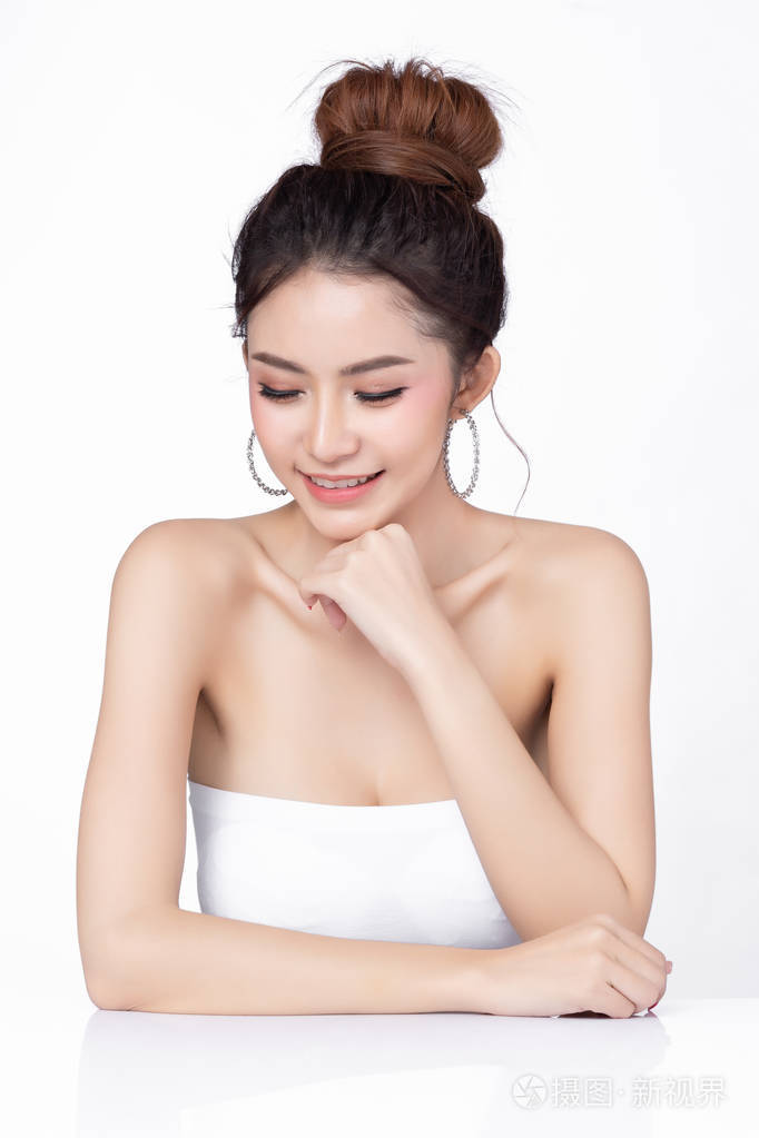 美丽的亚洲女人坐在白色背景上微笑的肖像健康肌肤女性自然妆容美容