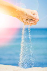 手在海边撒沙子照片