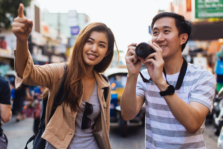 年轻的亚洲游客在城市里拍照图片