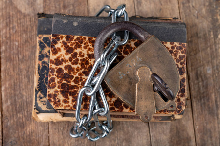 缠绕在浅棕色的粗麻布上骨架的链篦机一堆书,上面放着用铁链绑着的