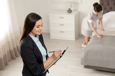 客房部经理检查客房服务员的工作照片