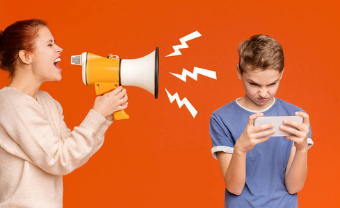 小玩意上瘾的男孩在手机上玩手机游戏照片