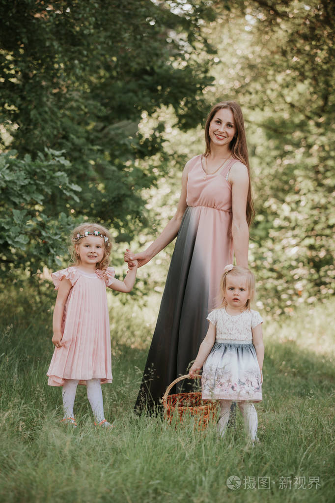 公园里有两个女儿的妈妈的画像母亲和两个女儿在旋转母亲牵着女儿们的