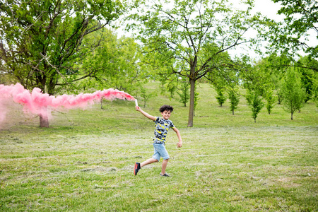 一个拿着粉色火炬跑的小男孩图片
