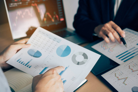 两位投资者正在合作分析股票数据照片