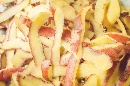 干净的新鲜土豆皮用特制的刀放在水槽上.照片