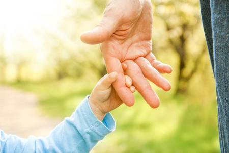 父母抱着孩子的手,背景很幸福照片