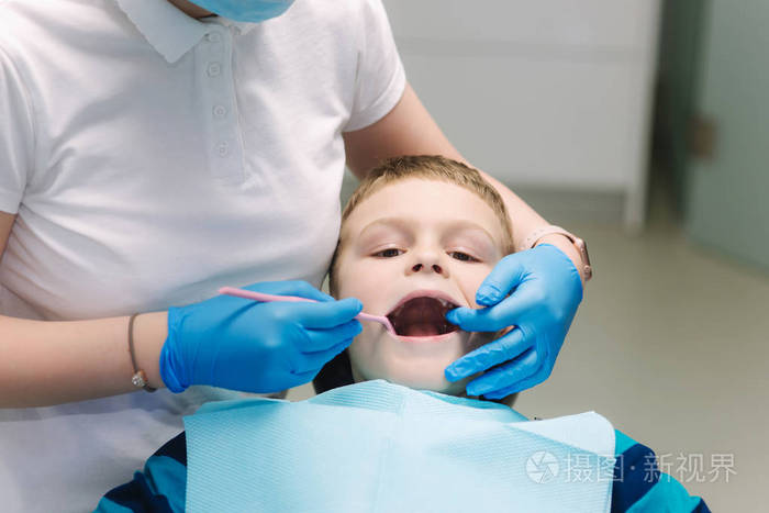 坐在办公室牙科椅上的小男孩儿童牙医检查婴儿牙齿