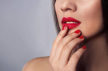 灰色指甲油灰色背景上涂着时尚指甲油的美女,特写.文本空间照片