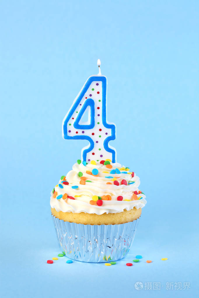 冰生日纸杯蛋糕配有点燃的4号蜡烛和花洒