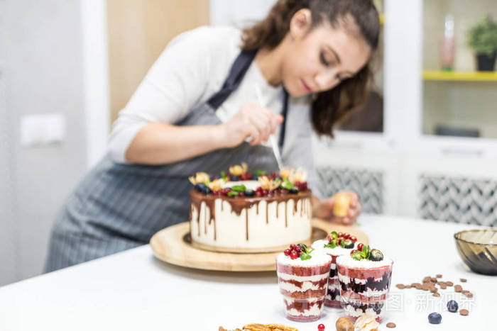 成品甜点的装饰糕点师傅在糖果上撒上黄色粉末自制糕点的概念做蛋糕