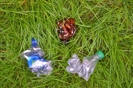 皱巴巴的塑料瓶皱巴巴的塑料瓶躺在草地上,垃圾堆在草地上照片