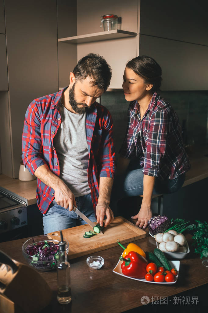女人坐在桌子上,他看着她的丈夫.家庭生活的场景.