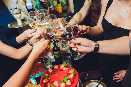 年轻人举杯庆祝这一事件.桌子上摆满了美味的食物和饮料.照片