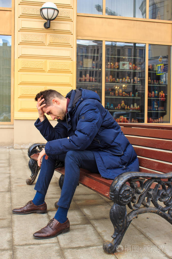 坐在长凳上心烦意乱的年轻人
