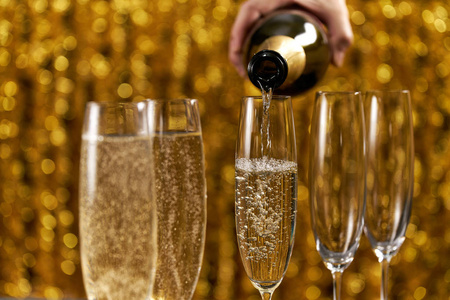 上面有冰,背景是金色的博克两杯香槟酒,背景金黄色两个香槟酒杯放在
