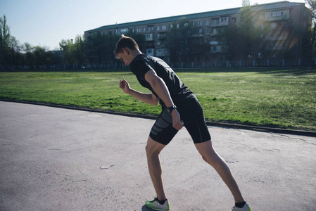 体育场的运动员站在起跑跑道上跑步照片