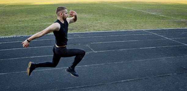 在橡胶跑道上跑步.穿着运动服的田径运动员.精力充沛的体育活动.