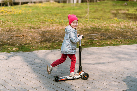 在公园里骑着滑板车的漂亮女孩.儿童pl照片