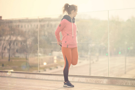 晨练跑步一位身穿粉色西装的年轻女子正在准备运动训练或跑步,晨练.