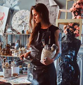 艺术家的一天这位年轻的艺术家在自己的画室里工作了一天之后正在整理