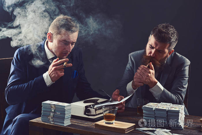 有现金的商业伙伴.商人一边喝酒一边抽烟一边写财务报告