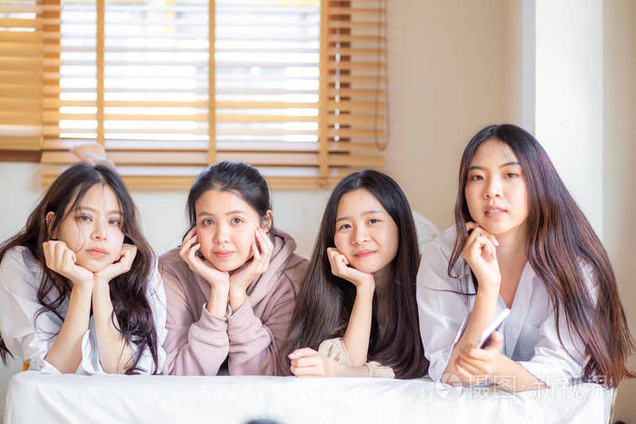 一群年轻漂亮的亚洲女性朋友在床上