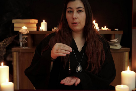 占卜钟摆空间一个穿着黑袍的巫婆是算命的,她手上的链子上有一个紫