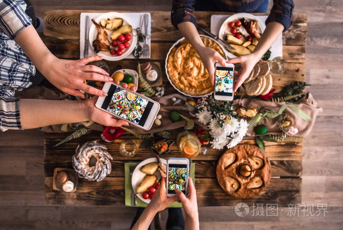 一群朋友在吃午饭前用手机拍照俯视图