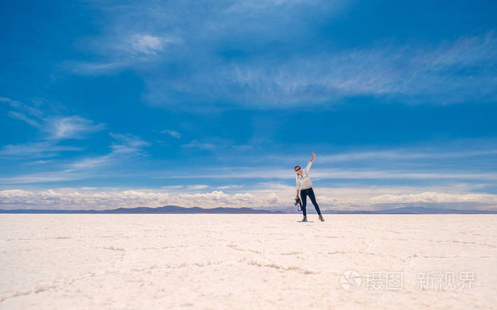 在阳光下跳跃的女孩Salar de Uyuni