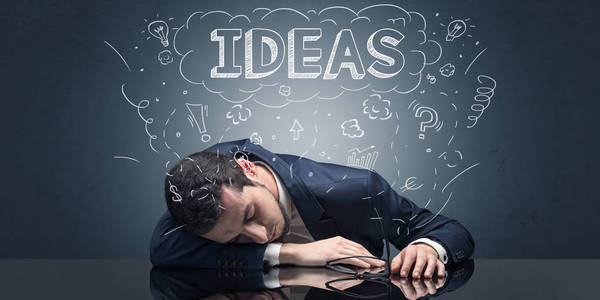 一个商人在工作场所睡着了,脑子里充满了想法,睡眠和疲惫的概念照片