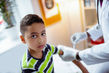 黑眼睛学龄前男孩看儿科医生打针医生注射儿童疫苗接种婴儿医生注射