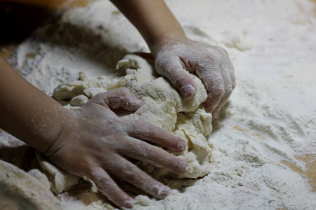 小男孩在揉面团.健康手工食品概念.烘焙产品,披萨,面粉.烹饪车间.