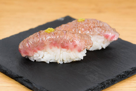 nigiri of heat-burned kobe beef dressed with mustard, served on