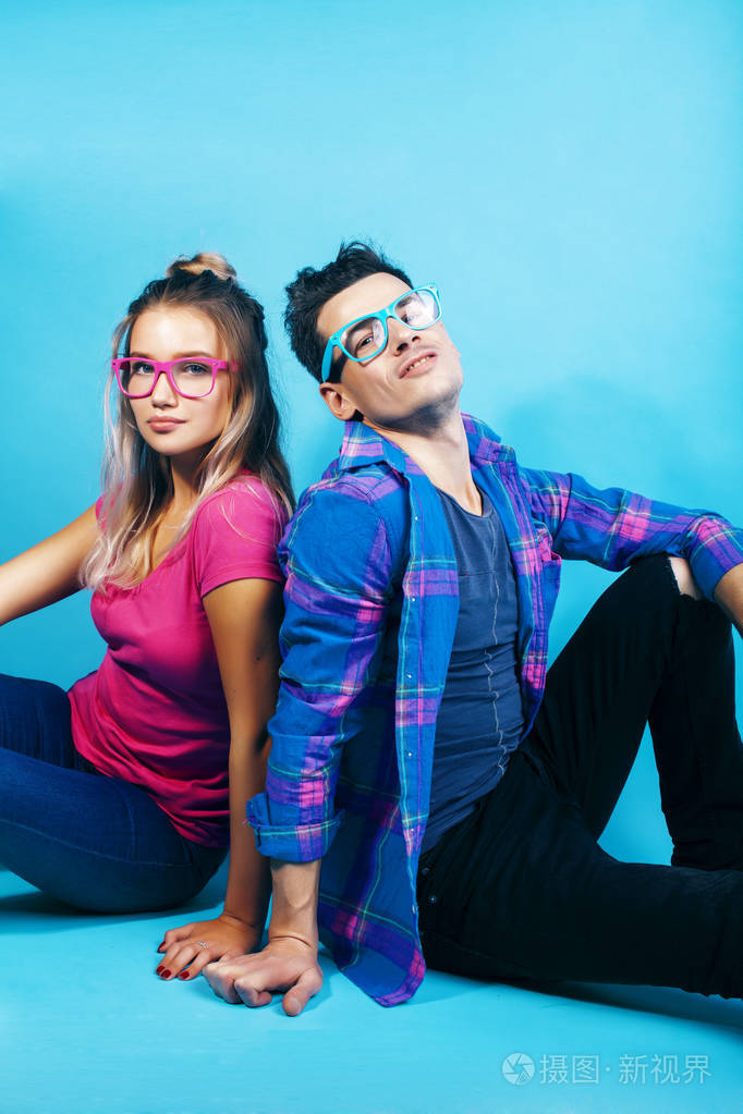 一对幸福的情侣戴着眼镜在蓝色的背景上摆出欢快的姿势男女同学在一起