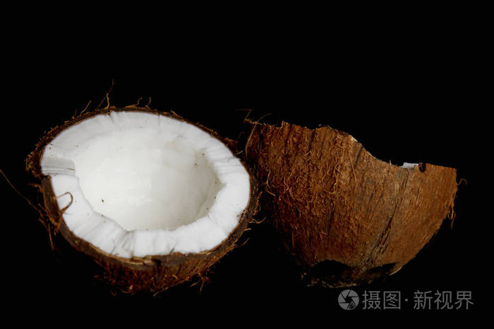 在黑色背景特写镜头中成熟的椰子被分成两半热带棕榈胎儿的内部