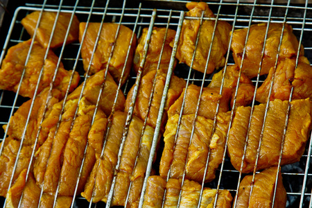 在火盆里烤架上的腌肉块.烤肉串在余烬外.烧烤野餐.俯视特写照片