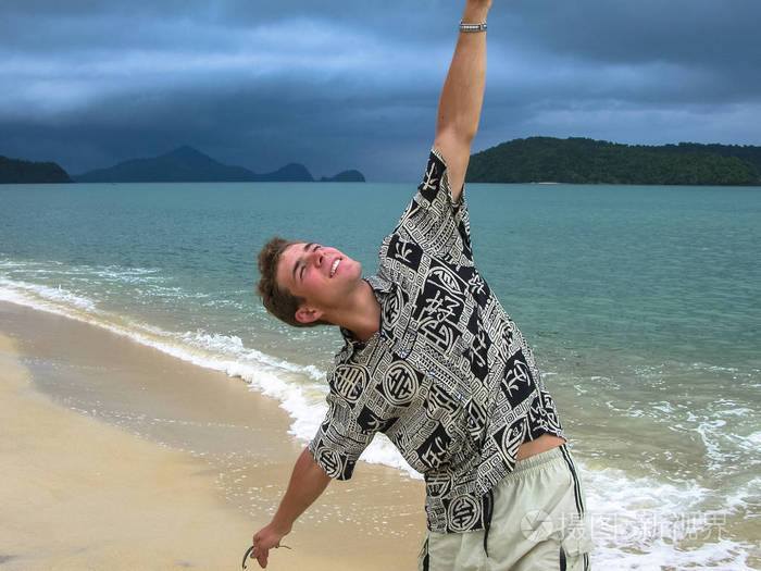 在异国情调的海滩上的帅哥在热带雨来临前在海滩上散步主题岛屿