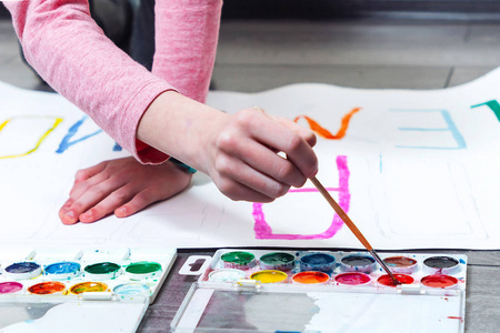 画扣篮一位年轻的女画家用刷子蘸颜料照片