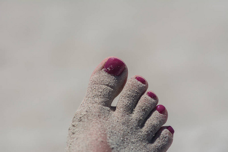 天然沙滩上红色脚趾甲的女人脚图片