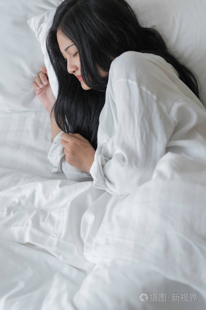 睡在卧室床上的漂亮年轻女子