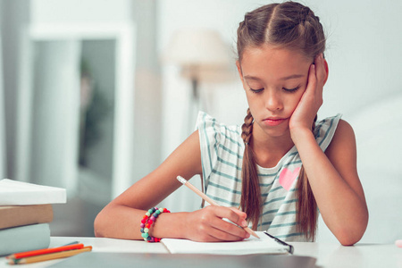 一个无聊可爱的美国黑人女孩在写作业.照片