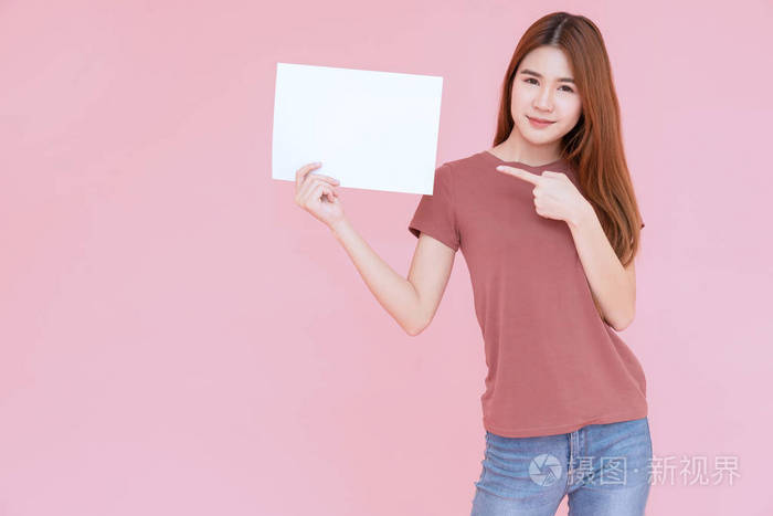 年轻的亚洲微笑女子举着广告牌,手指着.