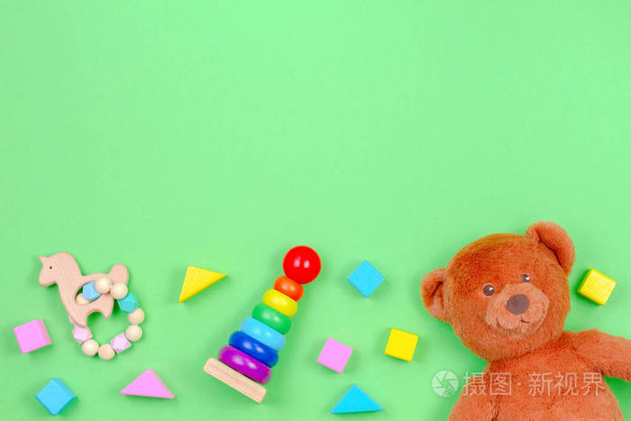 儿童玩具背景框与泰迪熊和彩色块在绿色背景